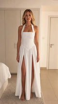 Front view of woman wearing white halter neck maxi dress with dual slits