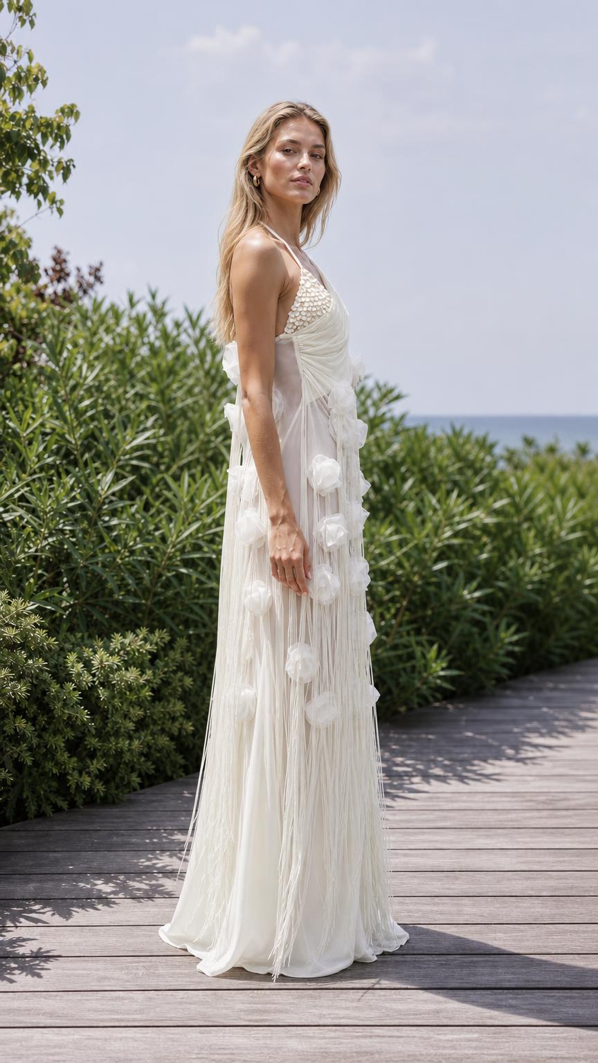 Side profile of white one-shoulder maxi dress on outdoor boardwalk