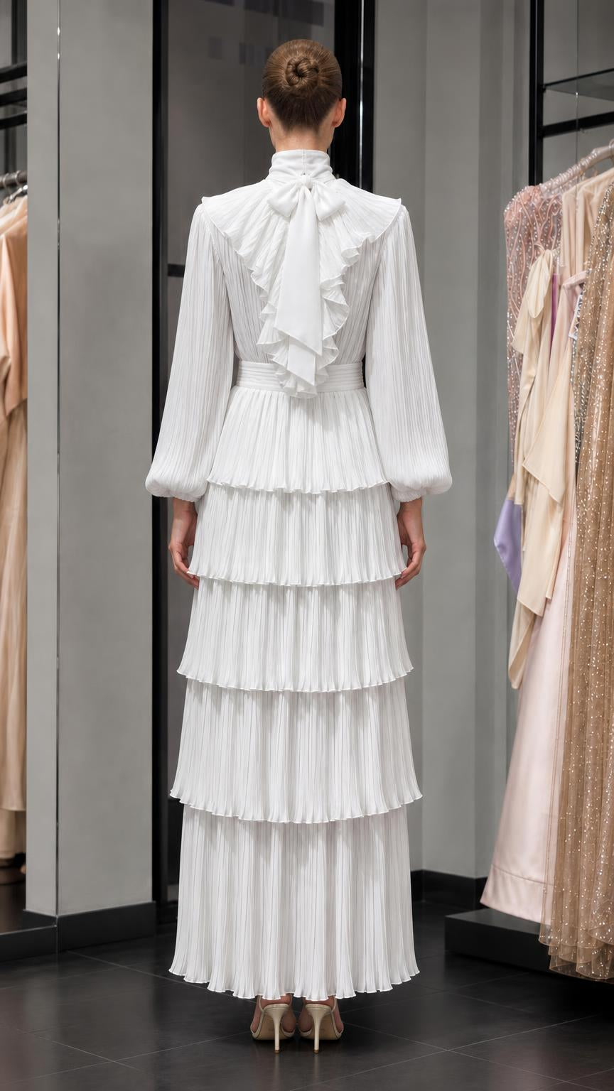 Back view of white pleated maxi dress with bow detail