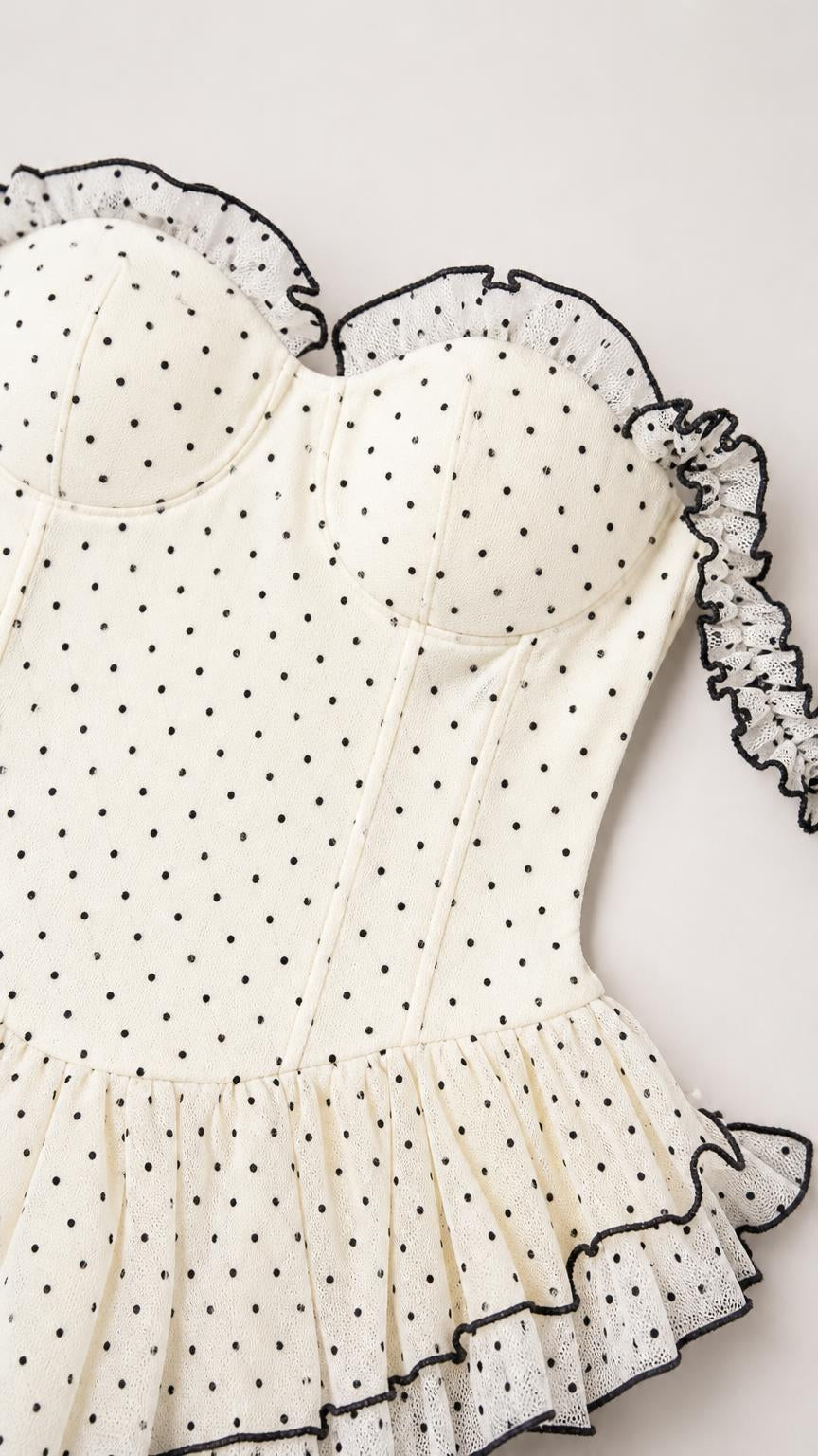 Close-up detail of white polka dot bodice and ruffle trim