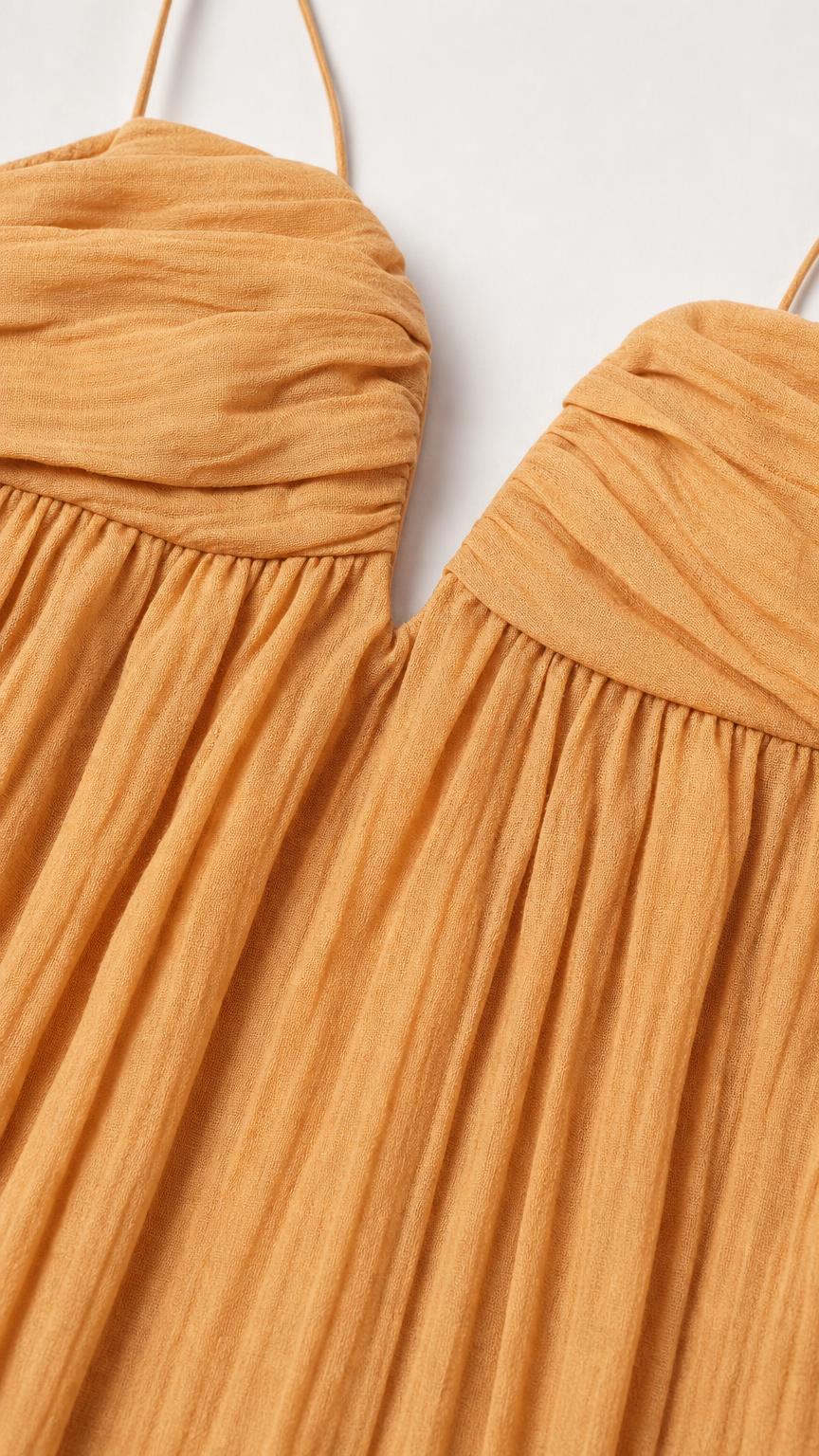 Close-up detail of ruched bodice texture on mustard yellow dress